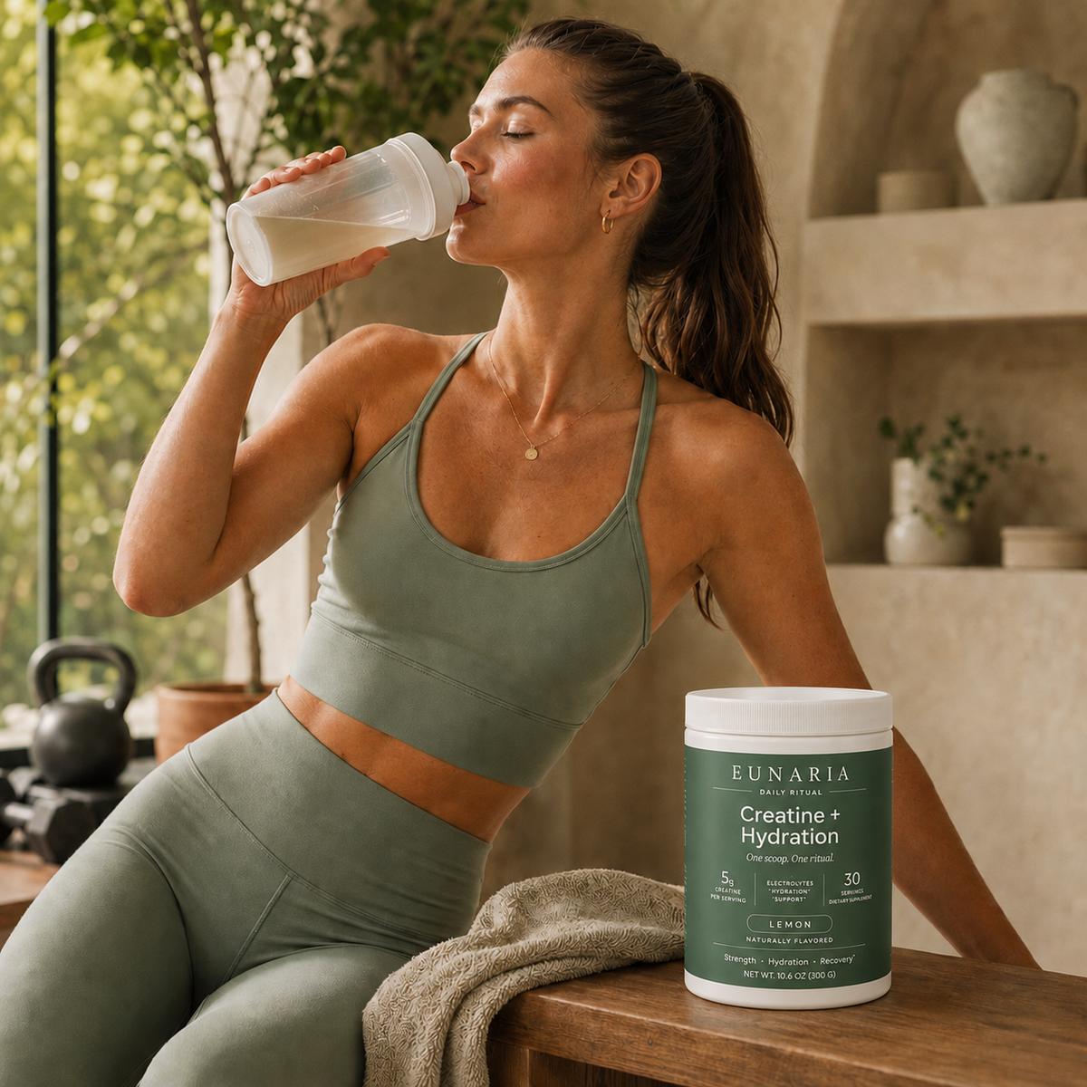 Woman drinking Eunaria Creatine + Hydration in a bright home setting